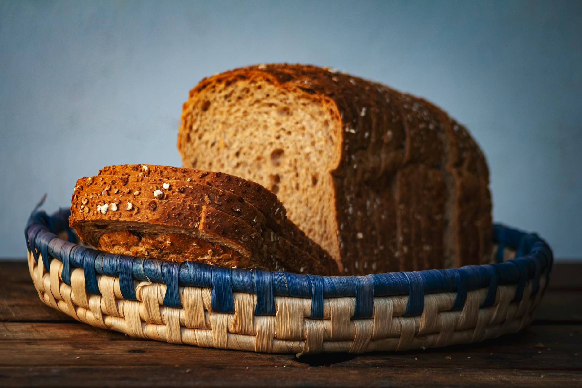 Close-up of sliced multigrain bread in a woven basket, perfect for food photography. (Photo by Arturo Añez. on Pexels)