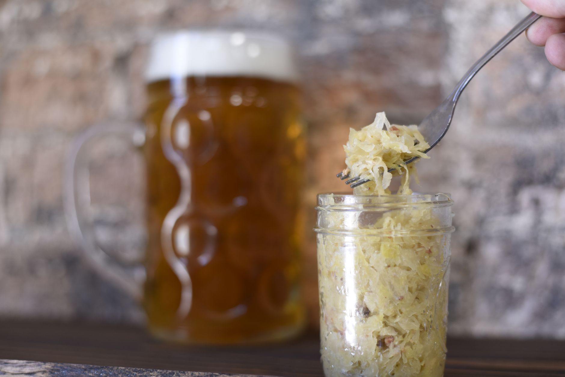 A rustic setting featuring a frothy beer mug and sauerkraut in a jar, perfect for pub themes. (Photo by ELEVATE on Pexels)